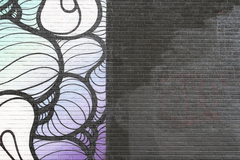 Free Image of Colorful street art on brick wall with swirling patterns 