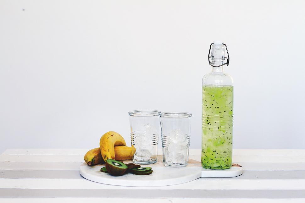 Free Image of Green infused drink with fruit slices in a glass bottle 