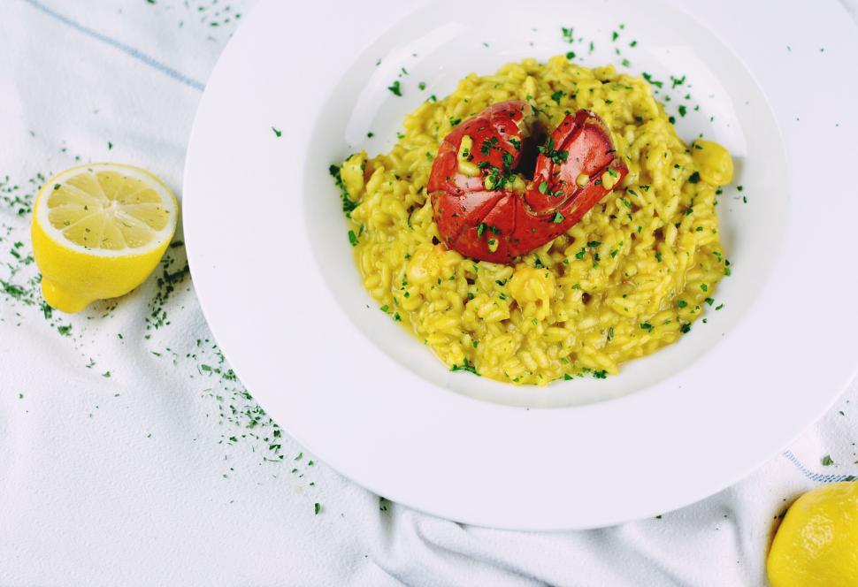 Free Image of A vibrant dish of yellow risotto with a red garnish 