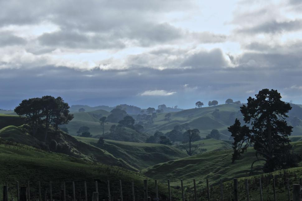 Free Image of Rolling green hills under cloudy morning sky 