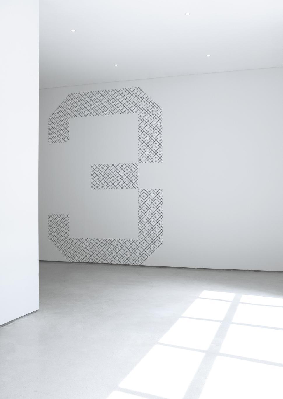 Free Image of Minimalist interior with large number three on the wall 