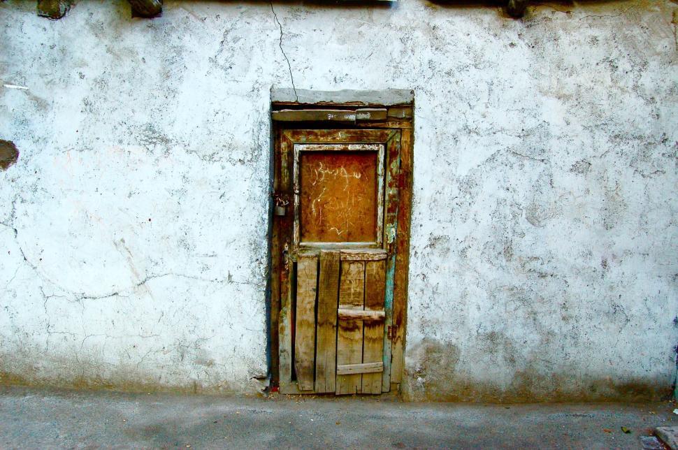 Free Image of Old, weathered door on dilapidated wall evoking nostalgia. 