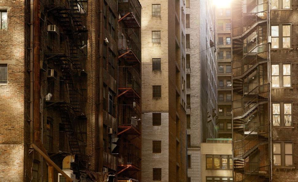 Free Image of Sunlight streaming through urban apartment buildings alley. 
