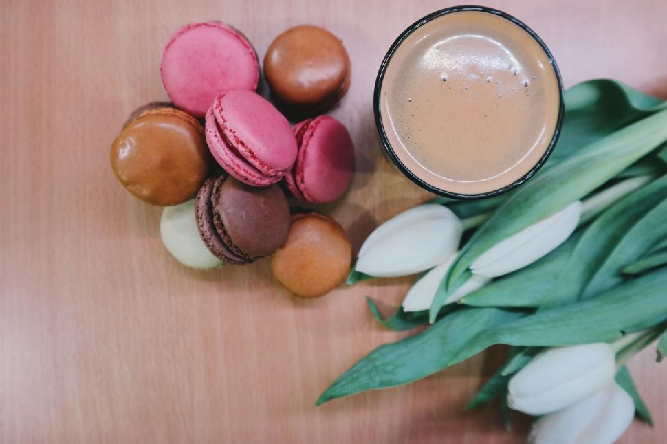 Free Image of Flat lay of macarons, coffee, and tulips on wooden table 