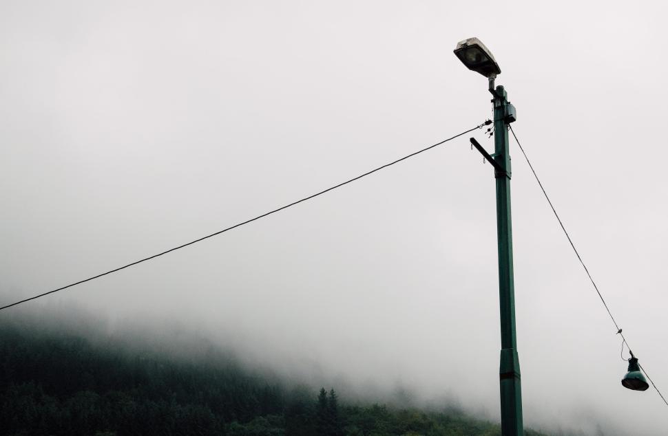 Free Image of Tall street light with misty mountain background view 