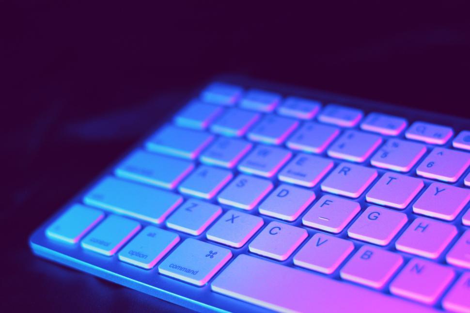Free Image of Illuminated keyboard with neon colors in a dark setting. 