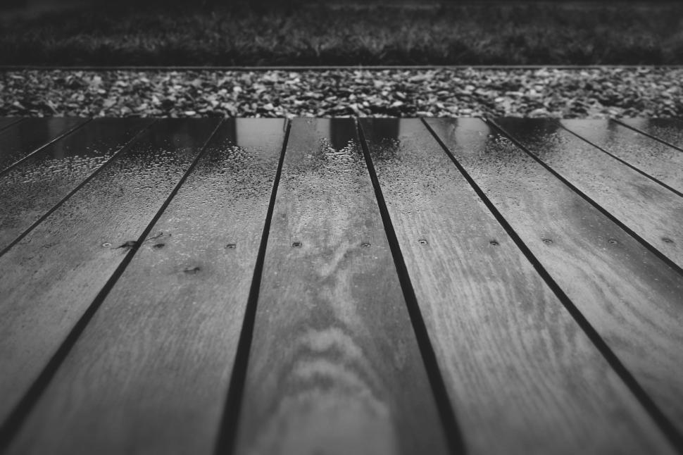 Free Image of Wet wooden deck with bright reflection after rainfall 