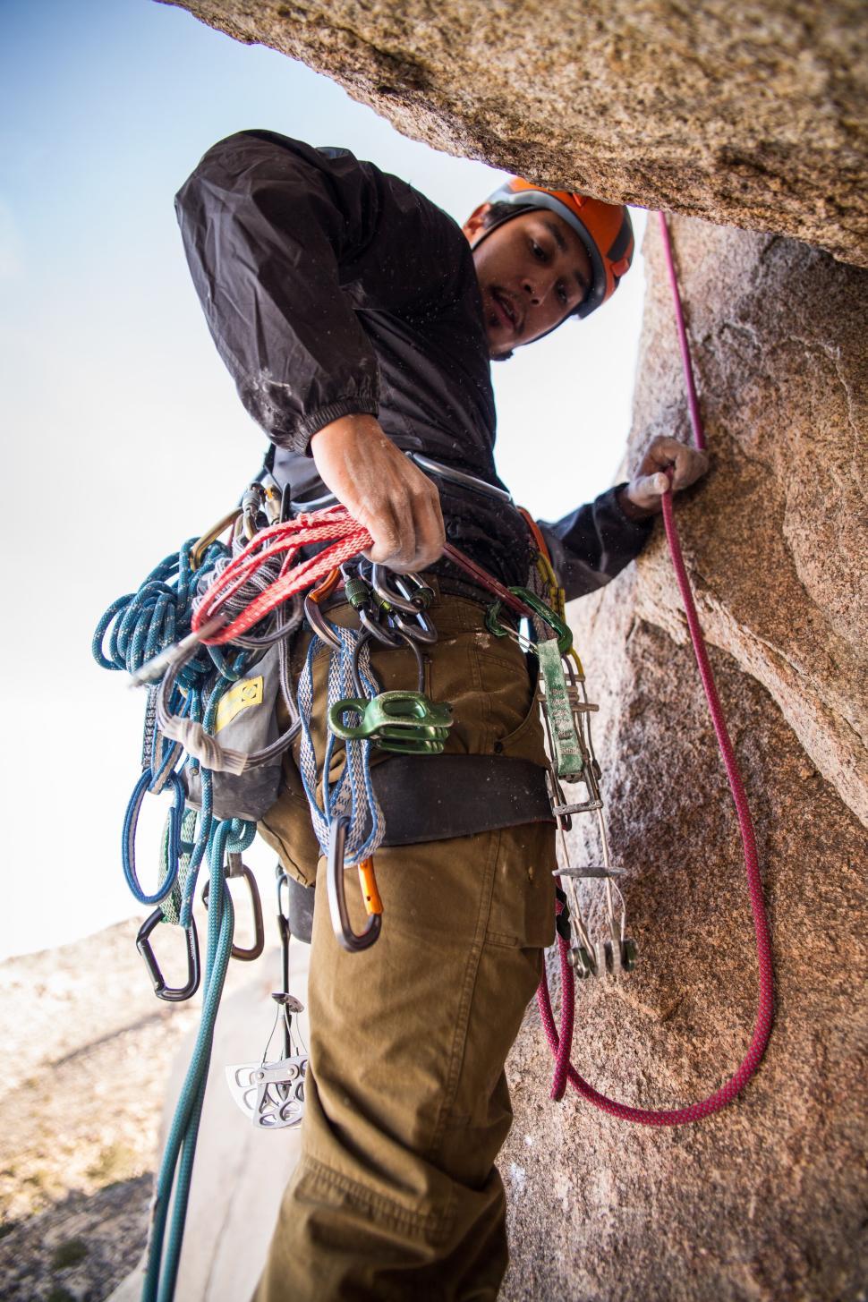 Free Image of Person with climbing gear ascending rocky mountain face. 