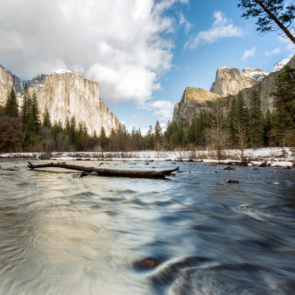 Free Image of Stream flowing through a mountain valley with snow. 