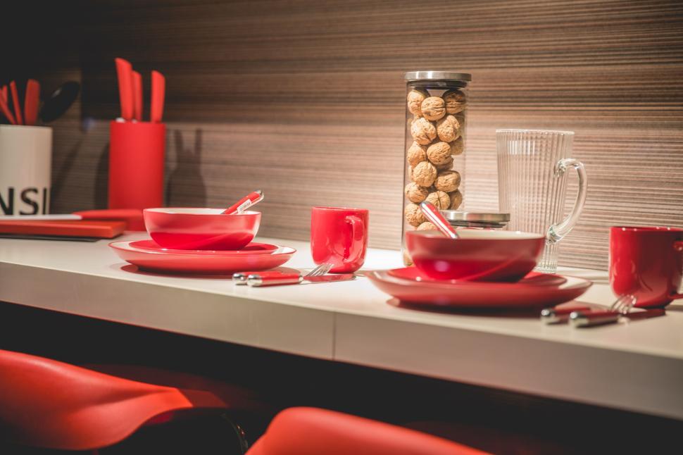 Free Image of Modern kitchen counter with red dishware set and utensils 