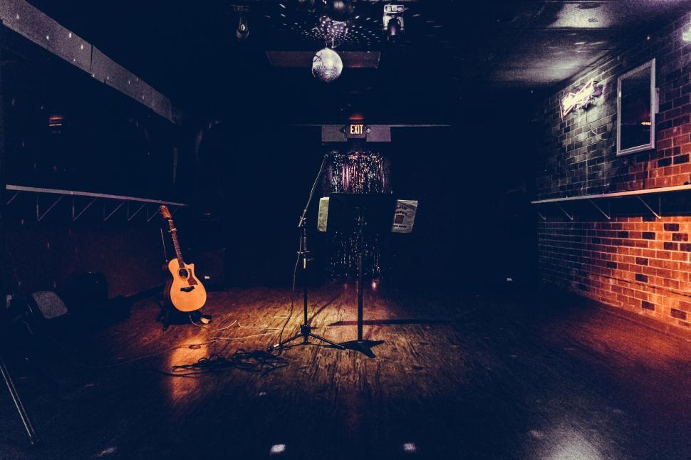 Free Image of Empty music stage with microphone and guitar on side 