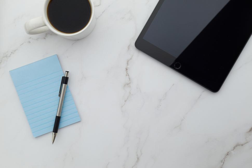 Free Image of Tablet with blue notepad, pen, and coffee on desk 