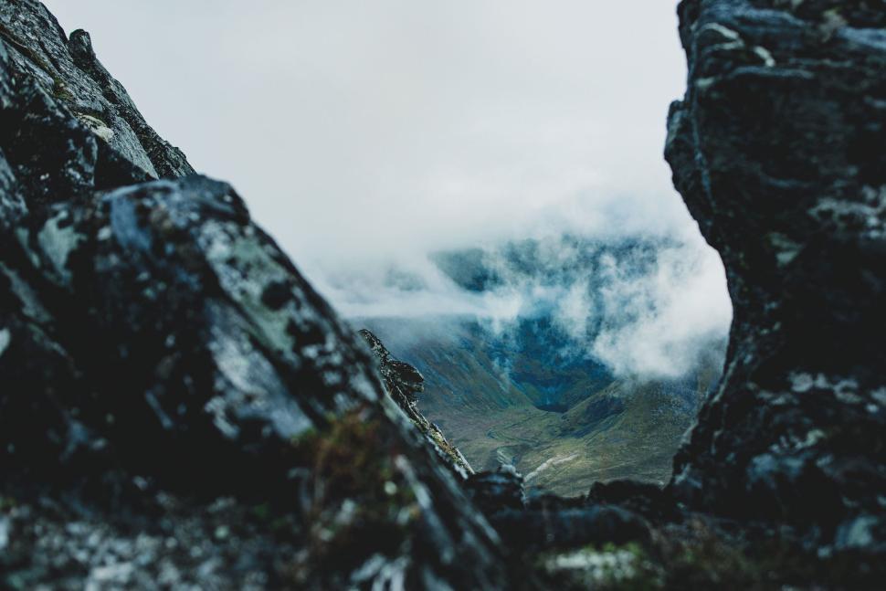 Free Image of Fog rolling through rocky mountain peaks at dawn 