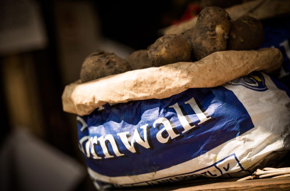 Free Image of Bag of potatoes from Cornwall on a wooden surface, rustic. 