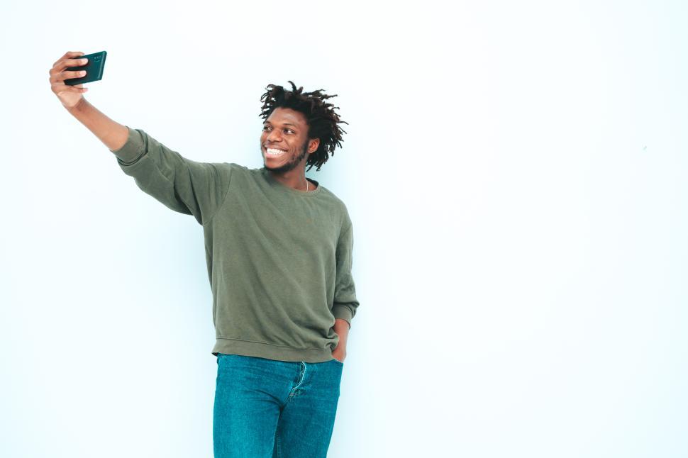 Free Image of Man taking selfie with one hand in green sweater. 