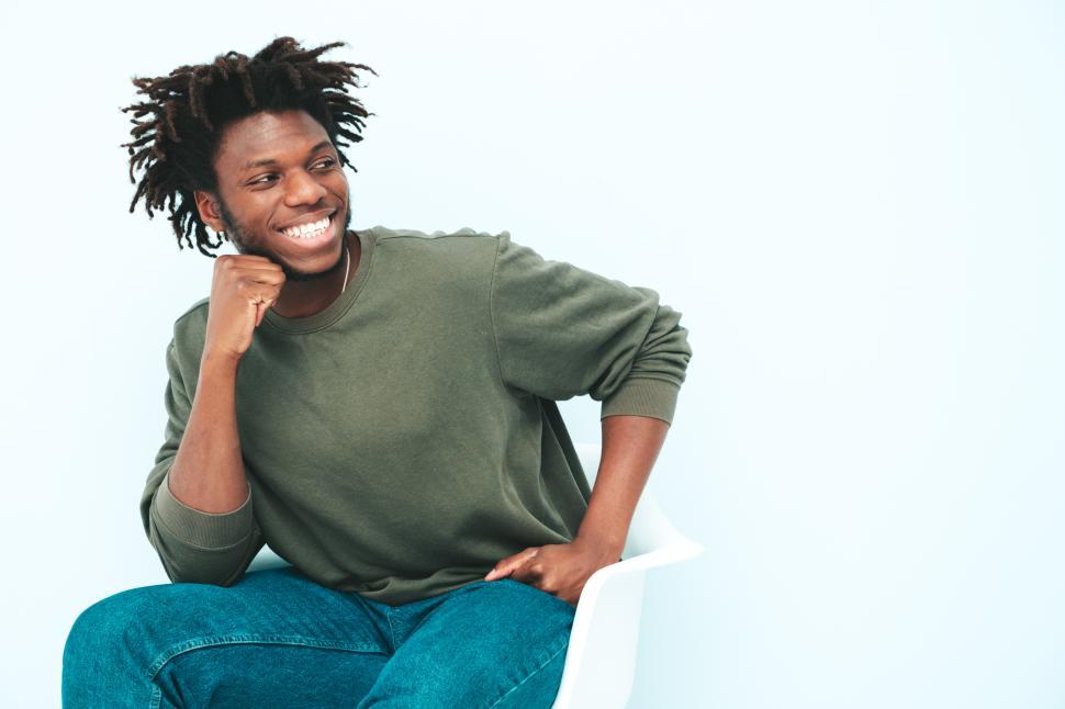 Free Image of Man sitting and smiling, dressed in green sweater. 