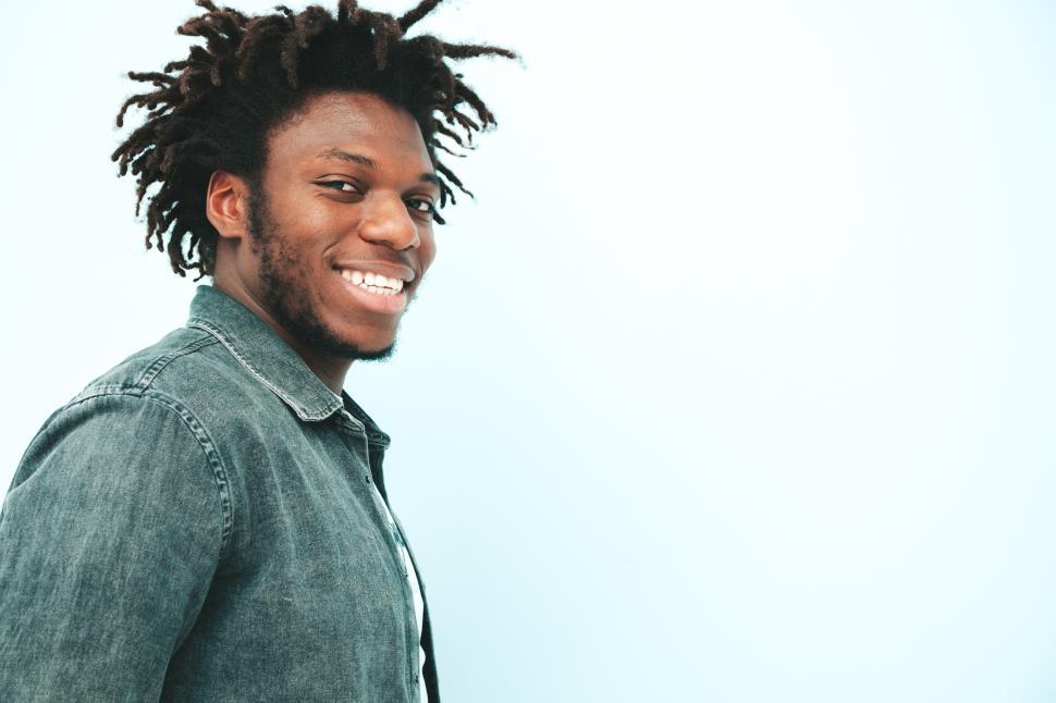Free Image of Smiling man with dreadlocks in denim shirt close-up. 