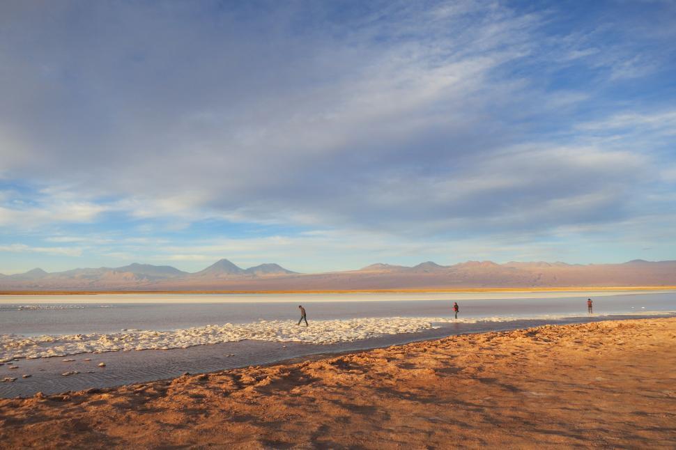Free Image of Distant figures walking near large tranquil lake view 