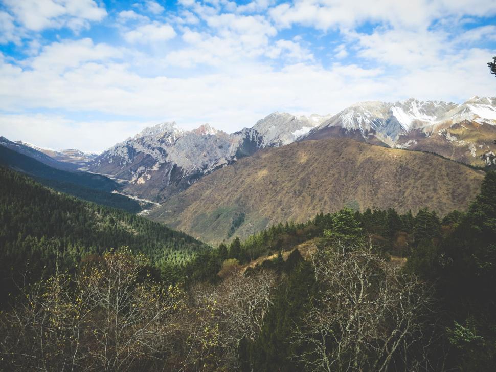 Free Image of Mountain range with green valleys and cloudy sky 