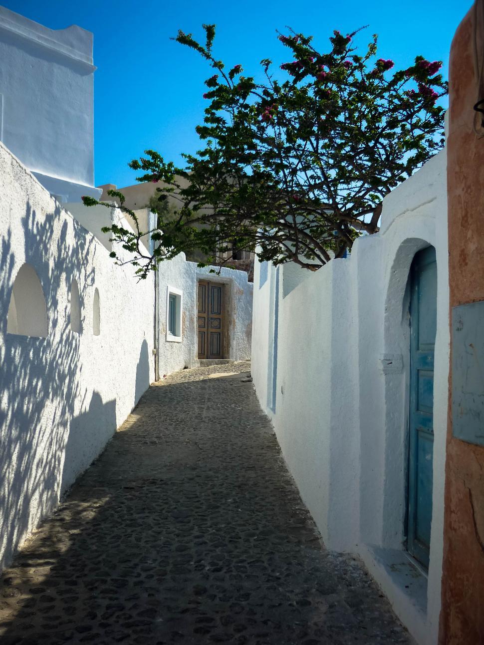 Free Image of Narrow alley in whitewashed village with blue doors 