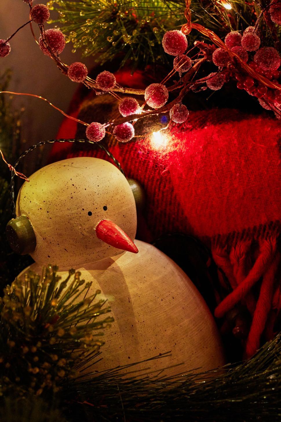 Free Image of Festive decor with wooden snowman and red blanket closeup. 