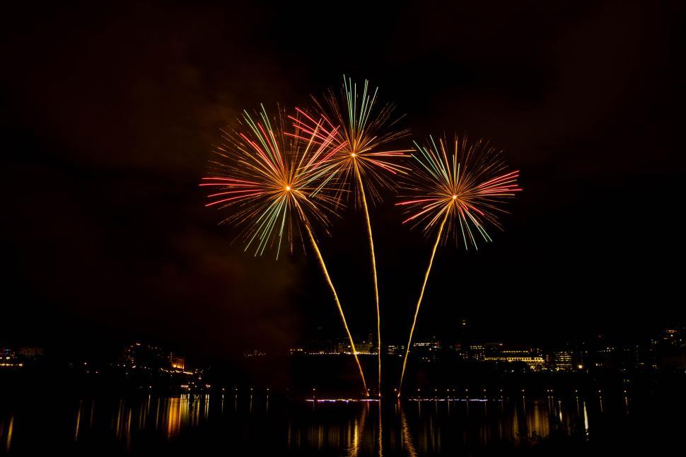 Free Image of Three colorful fireworks displayed in the night sky 