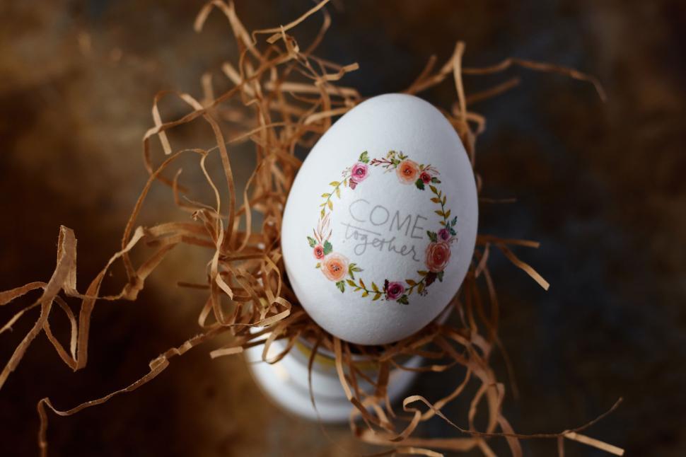 Free Image of Decorative egg with floral design and  Come Together  text 
