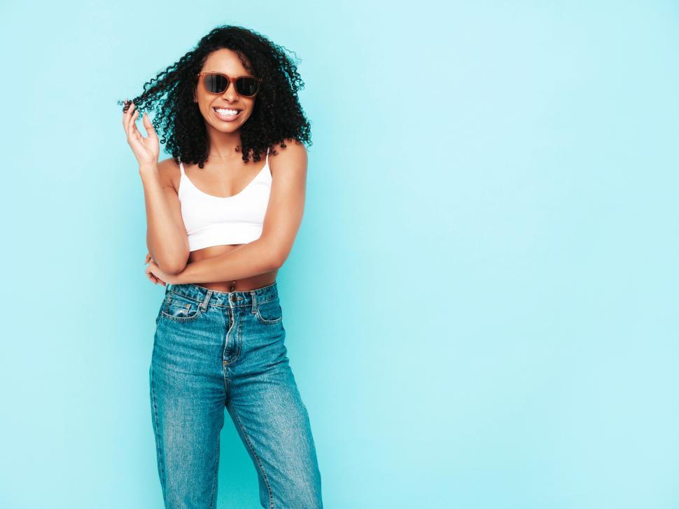 Free Image of Laughing woman in white top and jeans enjoying moment 