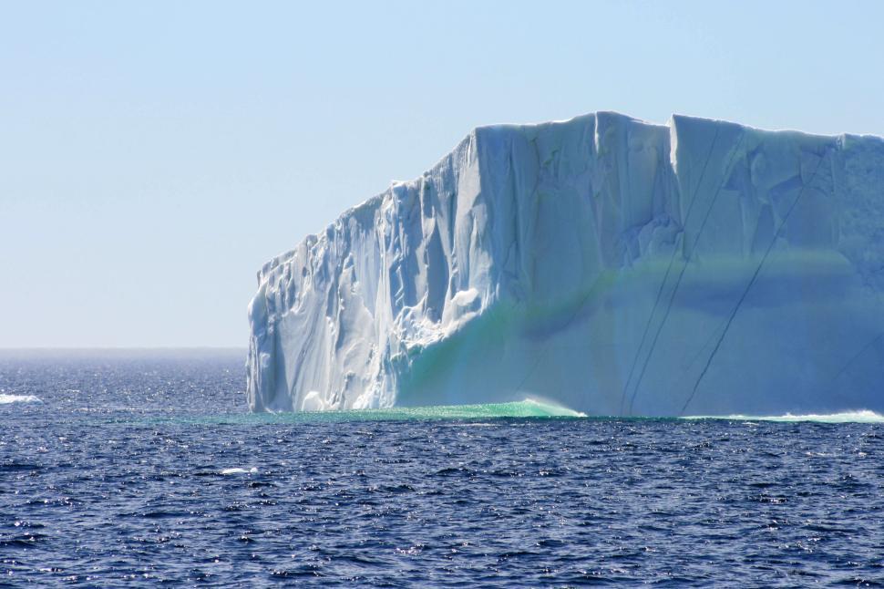 Free Image of Massive iceberg floating in the calm blue ocean water 