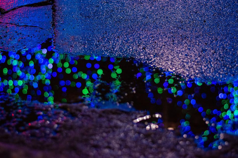 Free Image of Reflection of colorful lights in water at night 