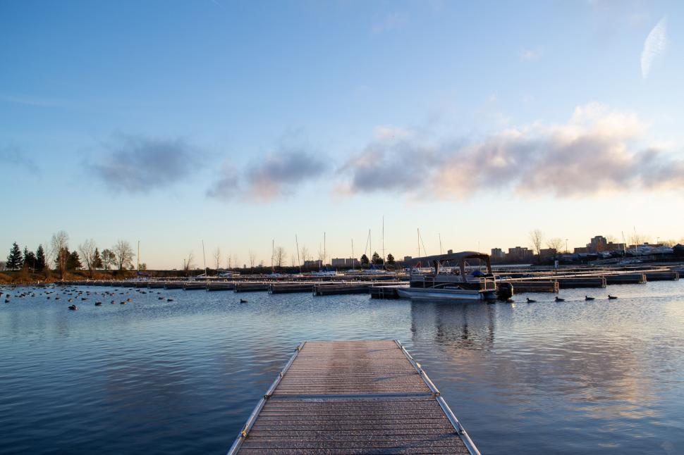 Free Image of Empty dock leading to a calm marina at sunrise. 