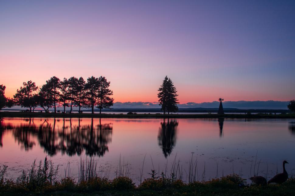Free Image of Scenic sunset over a tranquil lake with reflection. 