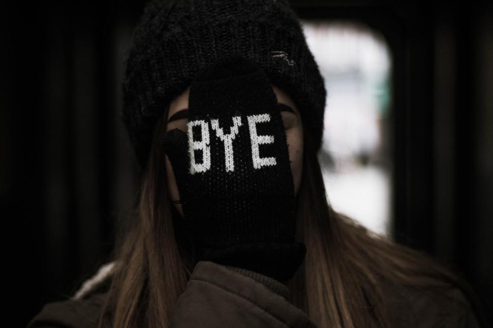 Free Image of Individual covering face with gloved hand in winter attire 