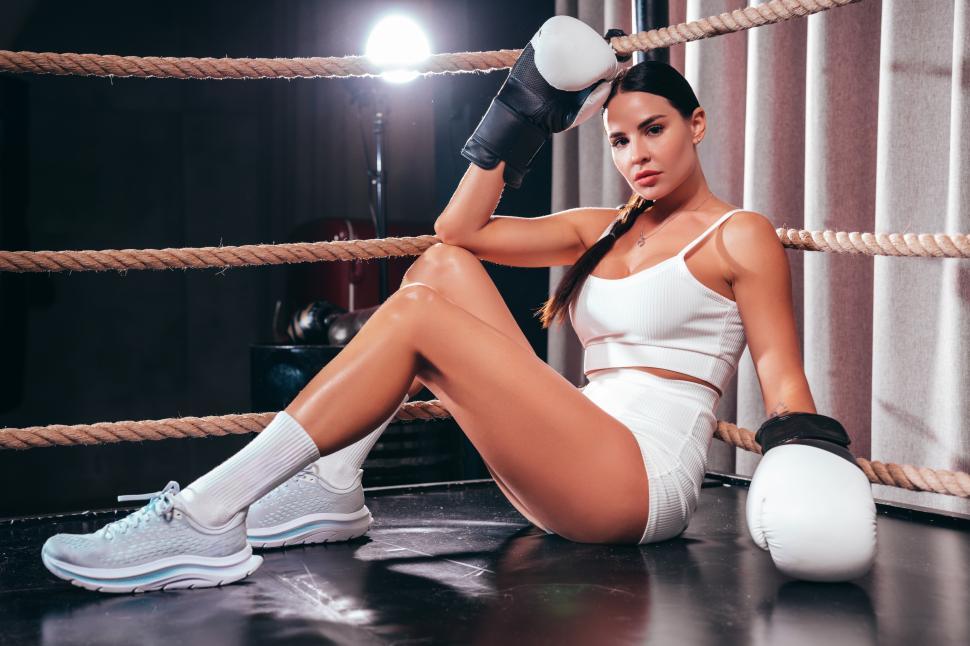 Free Image of Woman in boxing attire sitting in the ring, resting. 