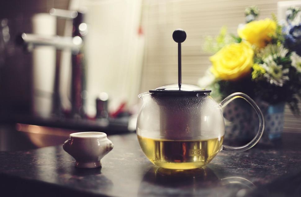 Free Image of Glass teapot with green tea and yellow flowers in kitchen 