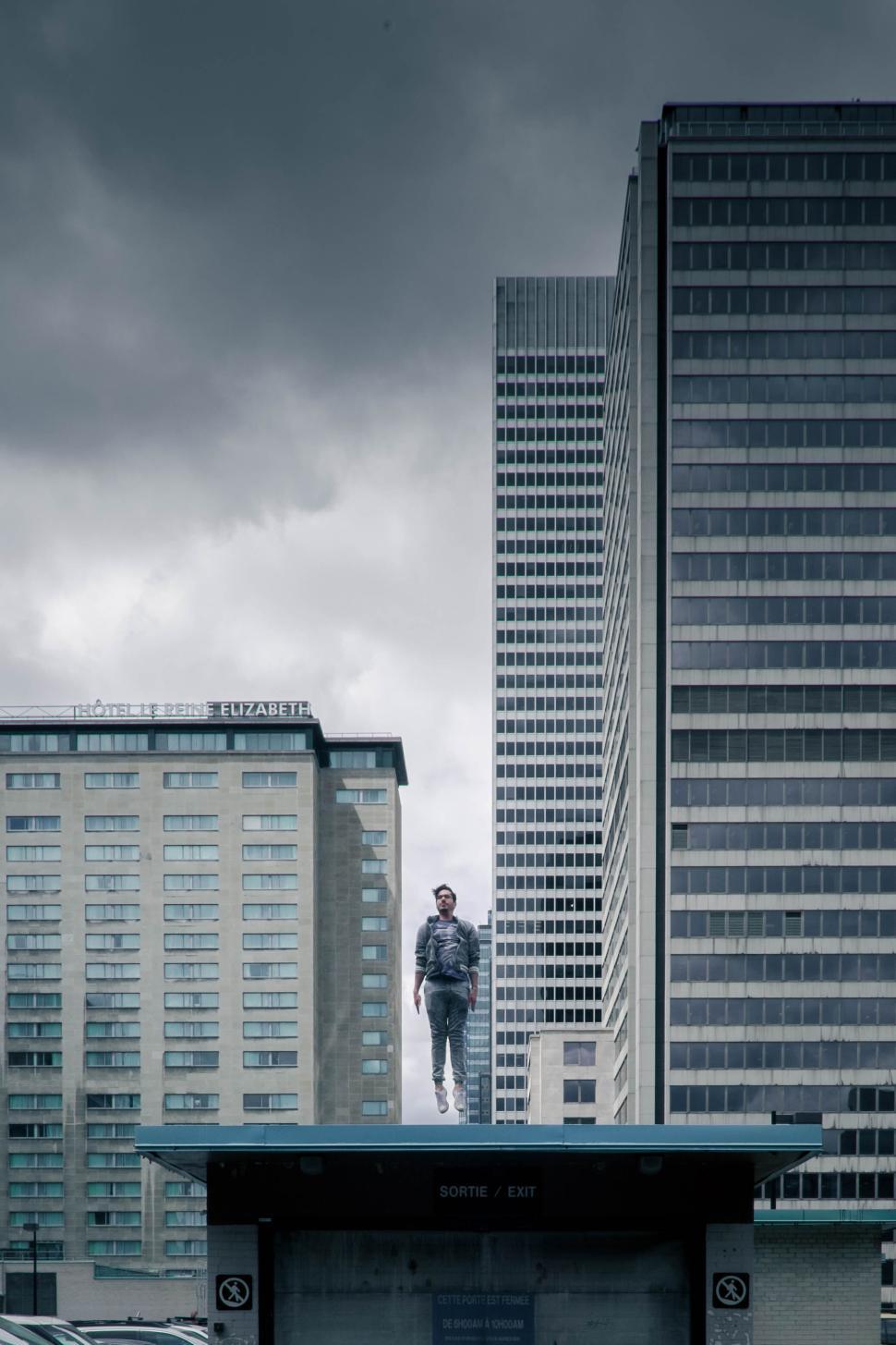 Free Image of Man statue standing prominently among tall buildings. 