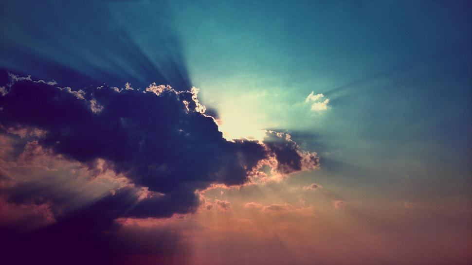 Free Image of Dramatic sky with sunrays piercing through dark clouds 