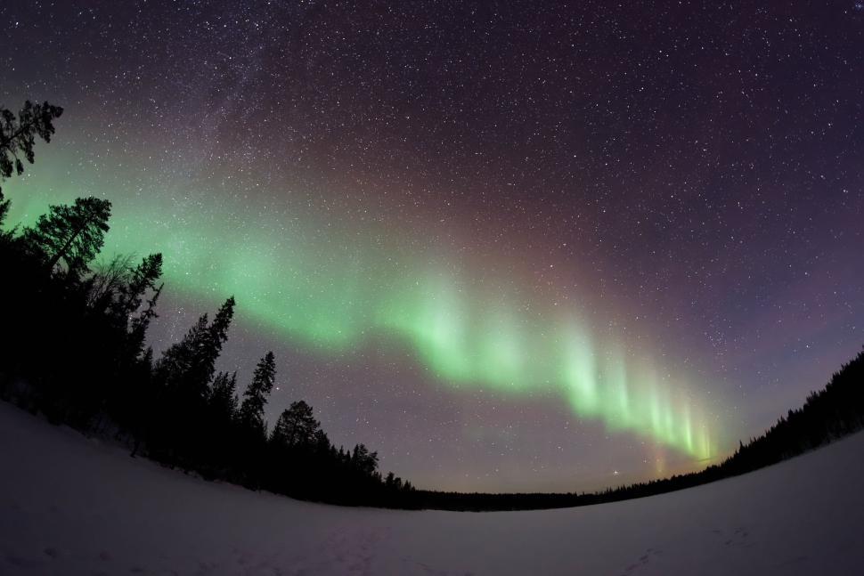 Free Image of Expansive Northern Lights arc across a clear, starry sky. 