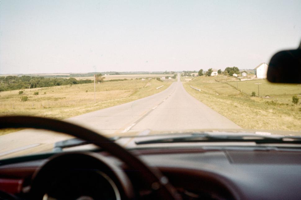 Free Image of Open road leading through grassy countryside landscape. 