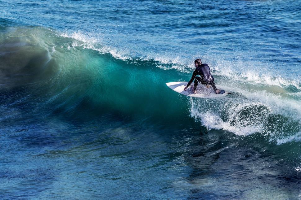 Free Image of Surfer riding a wave in the ocean 