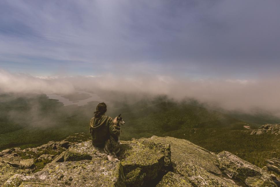 Free Image of Person with dog overlooking vast misty mountain landscape 