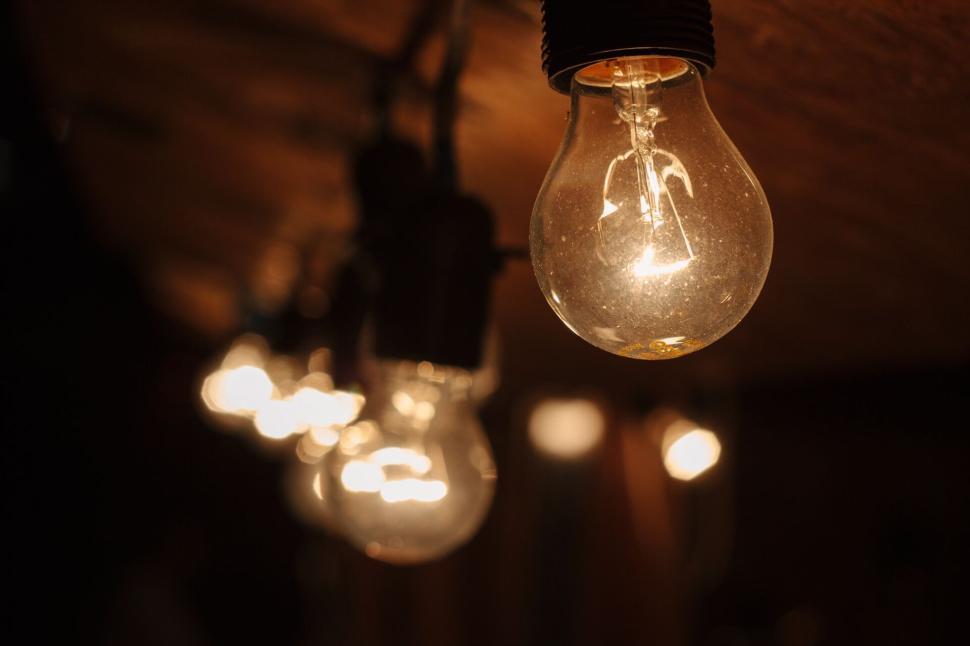 Free Image of Close-up of illuminated light bulbs in warm lighting 