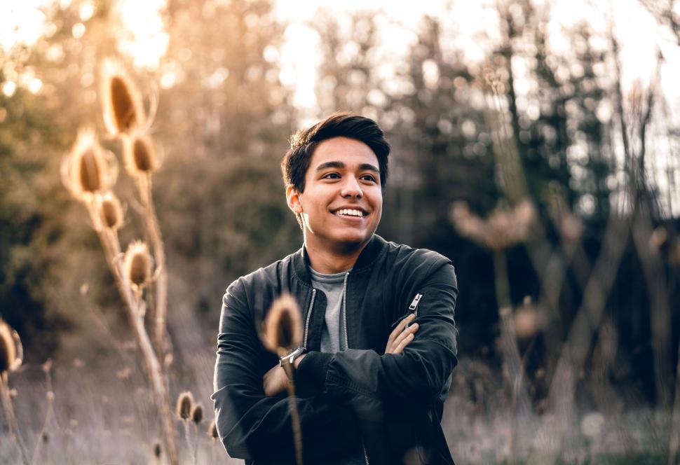 Free Image of Young man with folded arms smiling in golden sunlight 