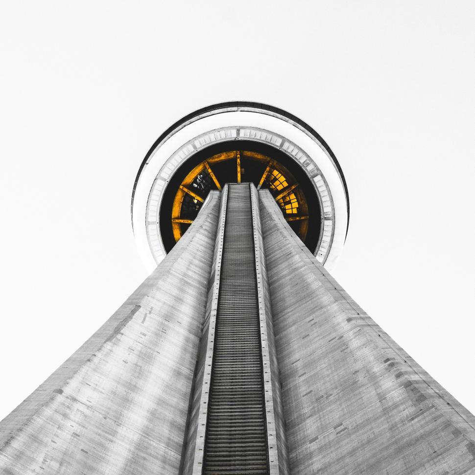 Free Image of Looking up at iconic concrete tower bathed in yellow light. 