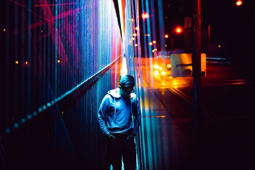 Free Image of Person standing under colorful lights at night outdoors. 