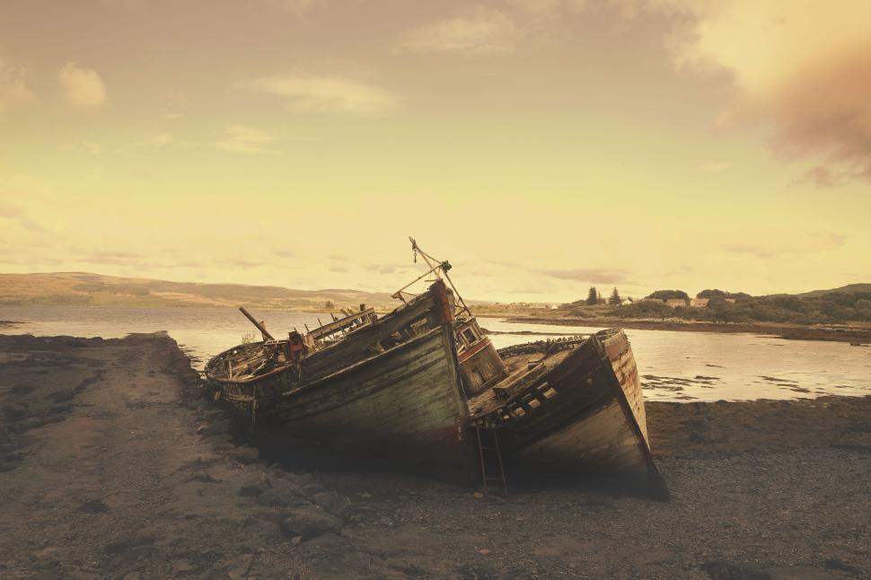Free Image of Abandoned wooden boats decaying on a deserted shore. 