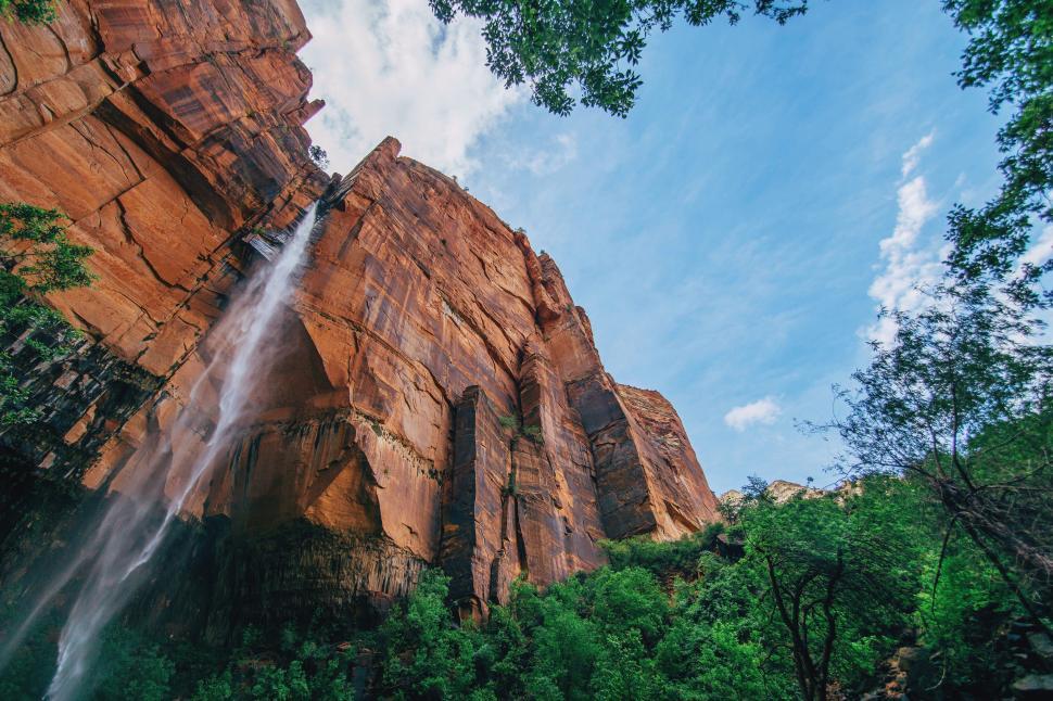Free Image of Tall waterfall cascading down red rock canyon 
