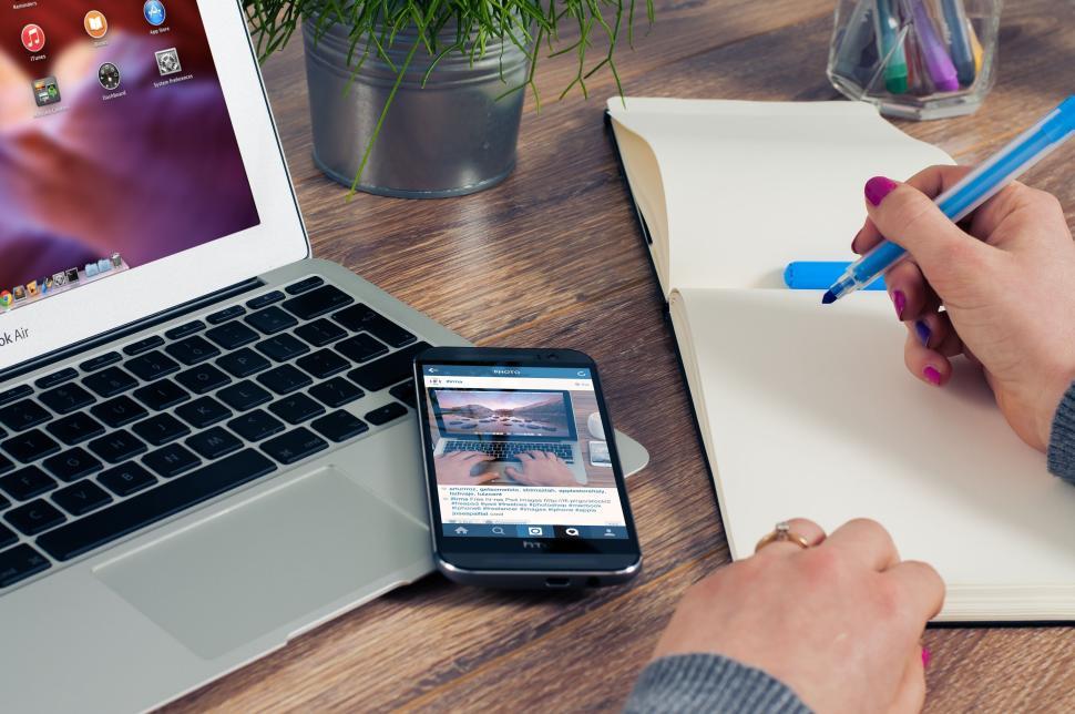 Free Image of Business setup with phone, laptop, and notebook on desk. 