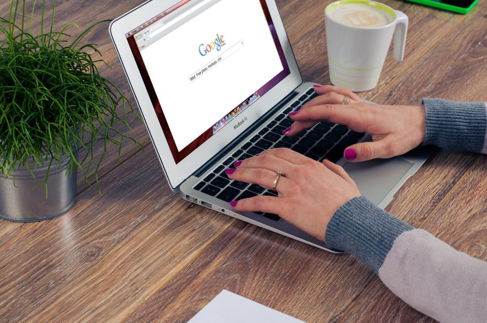 Free Image of Person typing on laptop with Google search page open. 