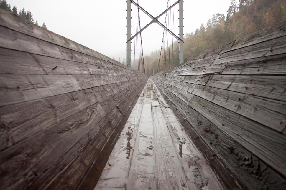 Free Image of Wet wooden bridge perspective with misty surroundings 